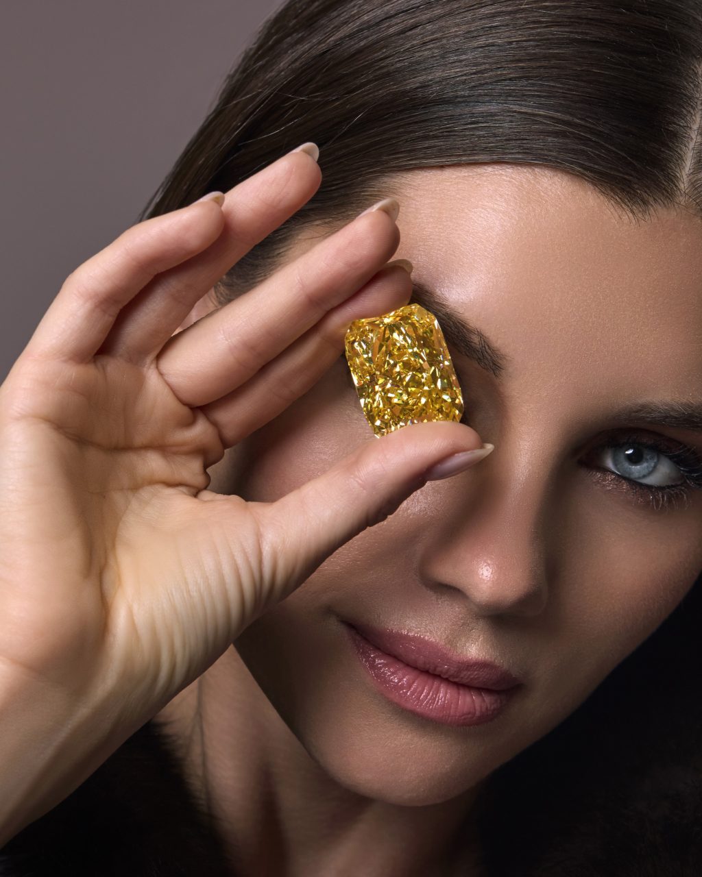 The Golden Royale Sun held by a model — Fancy Vivid Yellow Radiant Cut diamond